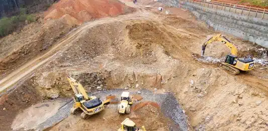 top view photography of four heavy equipment on quarry at daytime